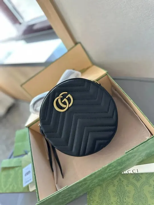 Zwarte gewatteerde ronde crossbodytas van Gucci met goudkleurig GG-logo