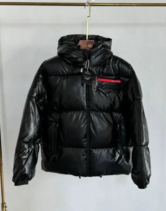 Chaqueta puffer negra brillante con capucha y detalle rojo del logo de Prada
