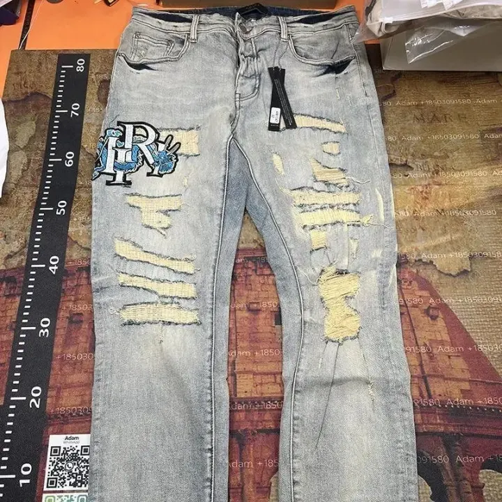 AMIRI Light Wash Distressed Denim Jeans with Graphic Patch